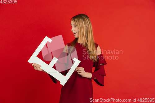 Image of Valentine\'s day celebration, happy caucasian girl holding letter on red background