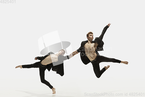 Image of Man in casual style clothes jumping and dancing isolated on white background. Art, motion, action, flexibility, inspiration concept. Flexible caucasian ballet dancer.