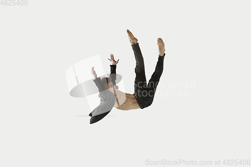 Image of Man in casual style clothes jumping and dancing isolated on white background. Art, motion, action, flexibility, inspiration concept. Flexible caucasian ballet dancer.