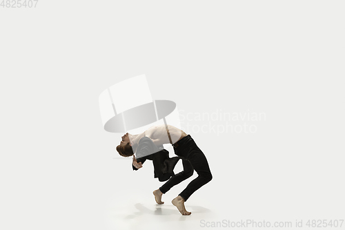 Image of Man in casual style clothes jumping and dancing isolated on white background. Art, motion, action, flexibility, inspiration concept. Flexible caucasian ballet dancer.