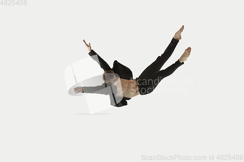 Image of Man in casual style clothes jumping and dancing isolated on white background. Art, motion, action, flexibility, inspiration concept. Flexible caucasian ballet dancer.