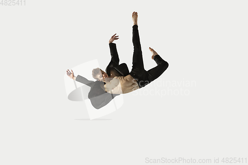 Image of Man in casual style clothes jumping and dancing isolated on white background. Art, motion, action, flexibility, inspiration concept. Flexible caucasian ballet dancer.