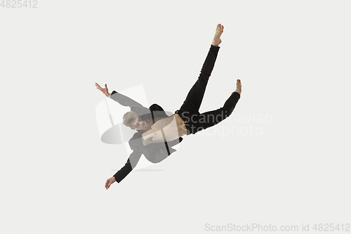 Image of Man in casual style clothes jumping and dancing isolated on white background. Art, motion, action, flexibility, inspiration concept. Flexible caucasian ballet dancer.