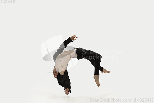 Image of Man in casual style clothes jumping and dancing isolated on white background. Art, motion, action, flexibility, inspiration concept. Flexible caucasian ballet dancer.