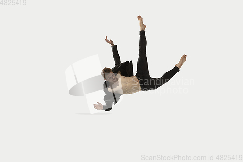 Image of Man in casual style clothes jumping and dancing isolated on white background. Art, motion, action, flexibility, inspiration concept. Flexible caucasian ballet dancer.