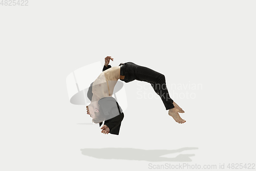 Image of Man in casual style clothes jumping and dancing isolated on white background. Art, motion, action, flexibility, inspiration concept. Flexible caucasian ballet dancer.