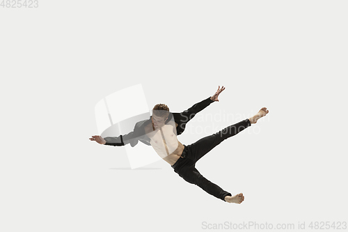 Image of Man in casual style clothes jumping and dancing isolated on white background. Art, motion, action, flexibility, inspiration concept. Flexible caucasian ballet dancer.