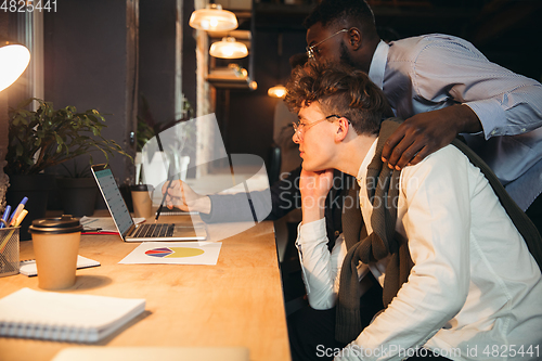 Image of Colleagues working together in modern office using devices and gadgets during creative meeting