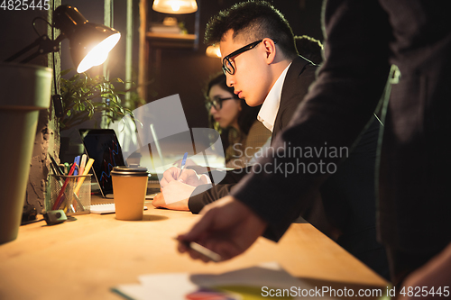 Image of Colleagues working together in modern office using devices and gadgets during creative meeting