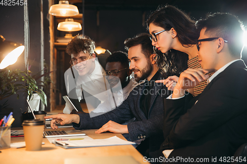 Image of Colleagues working together in modern office using devices and gadgets during creative meeting