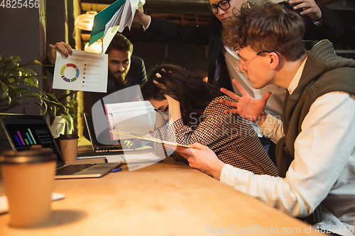 Image of Colleagues working together in modern office using devices and gadgets during creative meeting