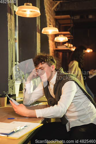 Image of Young man working together in modern office using devices and gadgets during creative meeting