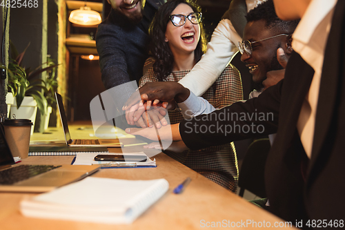 Image of Colleagues working together in modern office using devices and gadgets during creative meeting