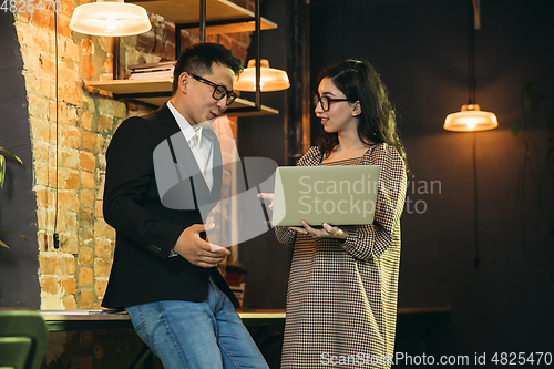 Image of Colleagues working together in modern office using devices and gadgets during creative meeting