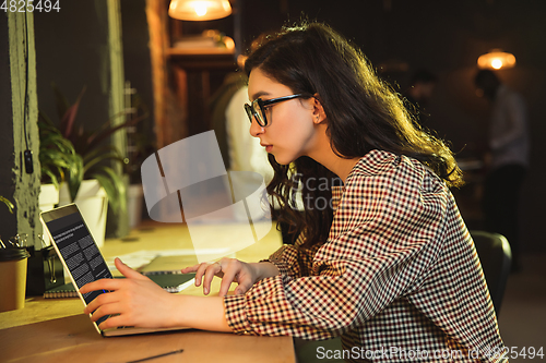 Image of Young woman working together in modern office using devices and gadgets during creative meeting