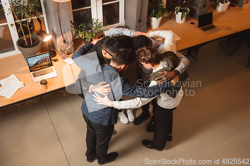 Image of Colleagues working together in modern office using devices and gadgets during creative meeting