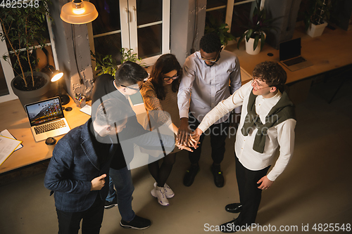 Image of Colleagues working together in modern office using devices and gadgets during creative meeting