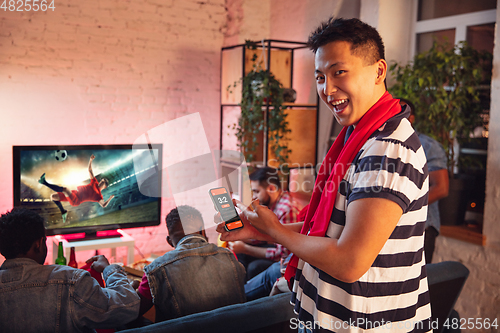 Image of Group of friends watching TV, sport match together. Emotional man cheering for favourite team, celebrating successful betting. Concept of friendship, leisure activity, emotions