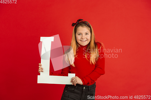 Image of Valentine\'s day celebration, happy caucasian girl holding letter on red background