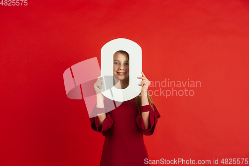 Image of Valentine\'s day celebration, happy caucasian girl holding letter on red background