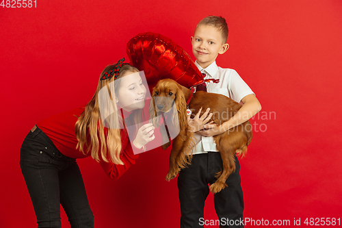 Image of Valentine\'s day celebration, happy caucasian teens isolated on red background