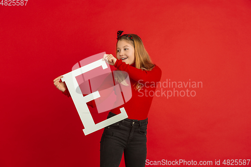 Image of Valentine\'s day celebration, happy caucasian girl holding letter on red background