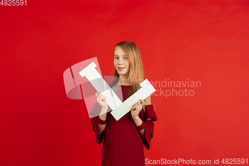 Image of Valentine\'s day celebration, happy caucasian girl holding letter on red background