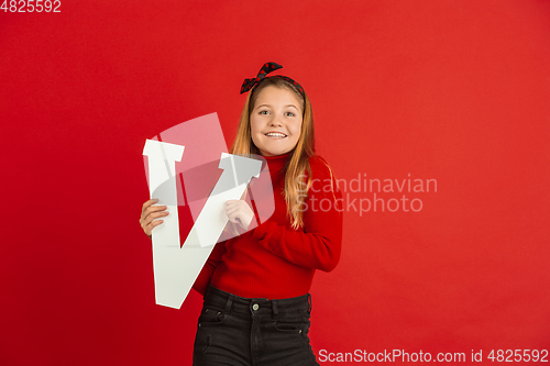 Image of Valentine\'s day celebration, happy caucasian girl holding letter on red background