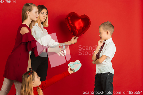 Image of Valentine\'s day celebration, happy caucasian teens isolated on red background