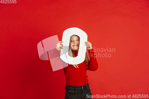 Image of Valentine\'s day celebration, happy caucasian girl holding letter on red background