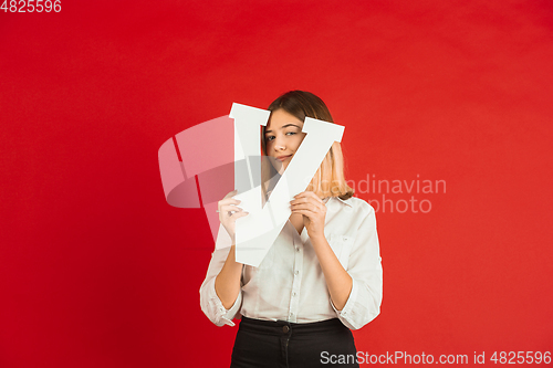 Image of Valentine\'s day celebration, happy caucasian girl holding letter on red background