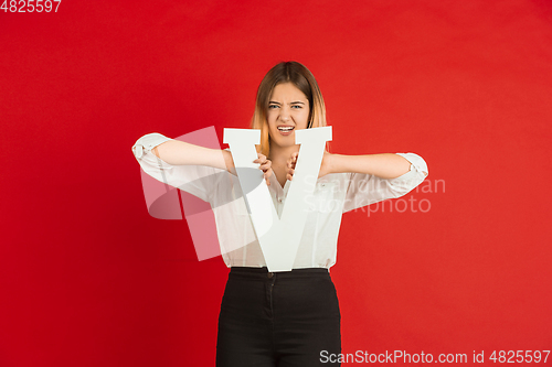 Image of Valentine\'s day celebration, happy caucasian girl holding letter on red background