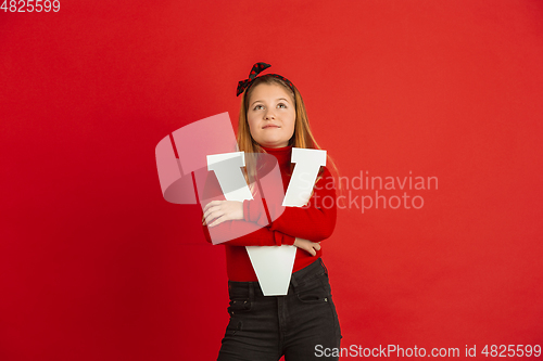 Image of Valentine\'s day celebration, happy caucasian girl holding letter on red background