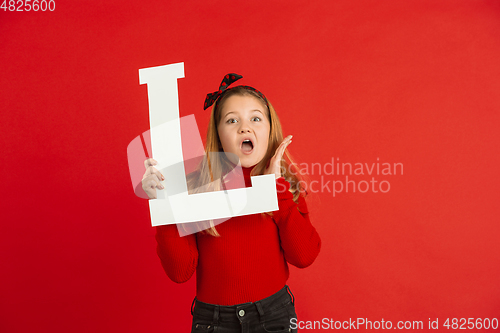 Image of Valentine\'s day celebration, happy caucasian girl holding letter on red background