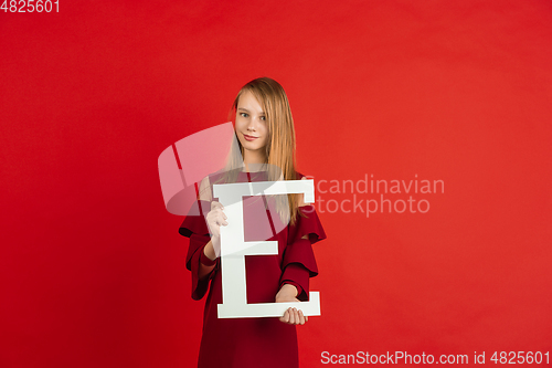 Image of Valentine\'s day celebration, happy caucasian girl holding letter on red background