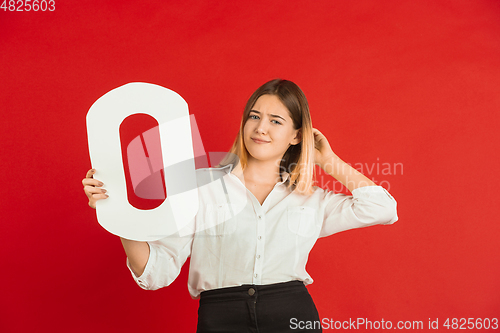 Image of Valentine\'s day celebration, happy caucasian girl holding letter on red background