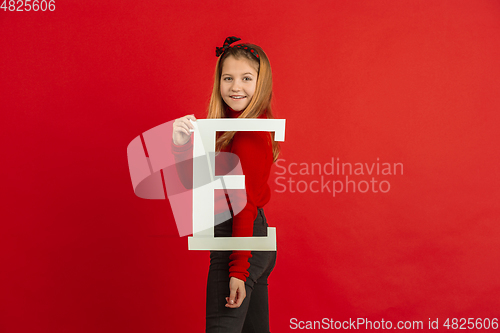 Image of Valentine\'s day celebration, happy caucasian girl holding letter on red background