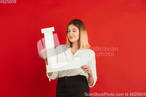 Image of Valentine\'s day celebration, happy caucasian girl holding letter on red background