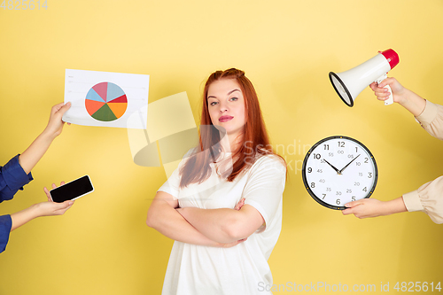 Image of Caucasian young woman\'s portrait on yellow background, too much tasks