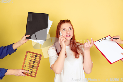 Image of Caucasian young woman\'s portrait on yellow background, too much tasks