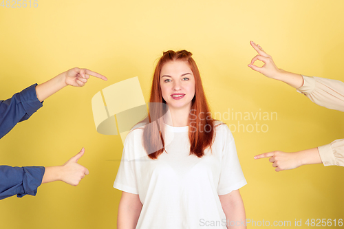 Image of Caucasian young woman\'s portrait on yellow background, too much tasks