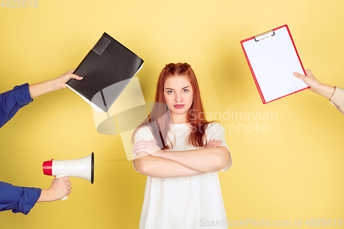 Image of Caucasian young woman\'s portrait on yellow background, too much tasks