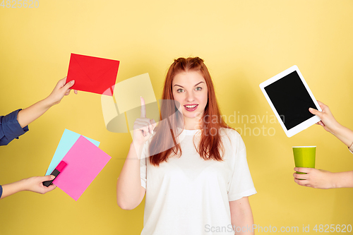 Image of Caucasian young woman\'s portrait on yellow background, too much tasks