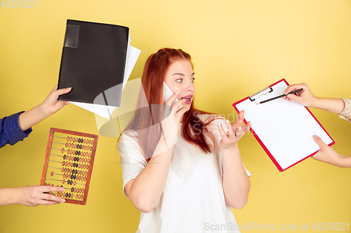 Image of Caucasian young woman\'s portrait on yellow background, too much tasks