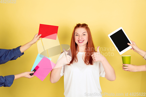 Image of Caucasian young woman\'s portrait on yellow background, too much tasks