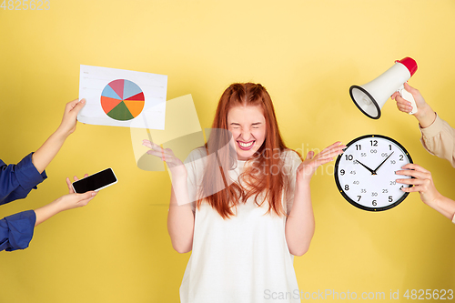 Image of Caucasian young woman\'s portrait on yellow background, too much tasks