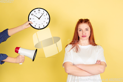 Image of Caucasian young woman\'s portrait on yellow background, too much tasks