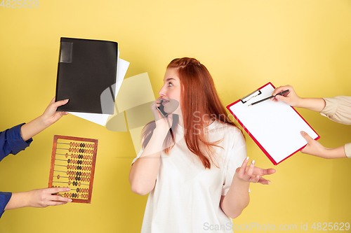 Image of Caucasian young woman\'s portrait on yellow background, too much tasks