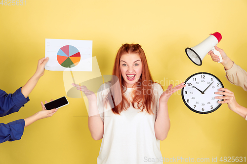 Image of Caucasian young woman\'s portrait on yellow background, too much tasks