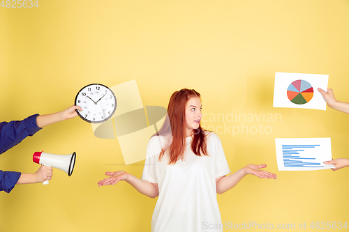 Image of Caucasian young woman\'s portrait on yellow background, too much tasks